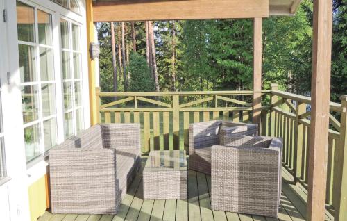 a porch with wicker chairs and tables on a deck at Stunning Home In Lidhult With Lake View in Lidhult