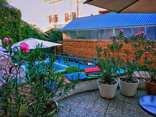 a garden with plants and pillows on a patio at Sapar Standart Hotel in Shymkent