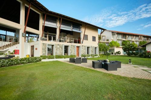 a large building with a lawn in front of it at The Calm Resort & Spa in Pasikuda