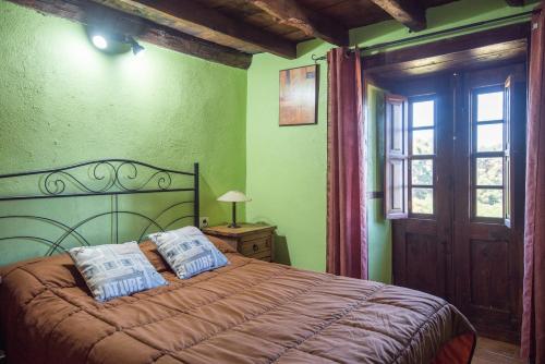 um quarto com uma cama com duas almofadas em Casa Rural de Abuelo - Con zona habilitada para observación astronómica em Hoyagrande