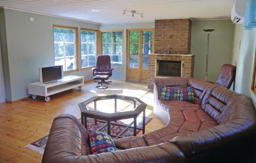 a living room with a leather couch and a fireplace at Holiday Home Färjestaden 20 in Vanserum