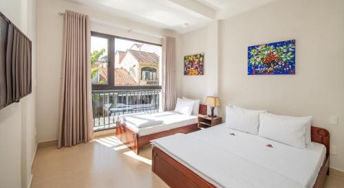 a bedroom with two beds and a large window at Backhome Hostel & Bar in Hoi An