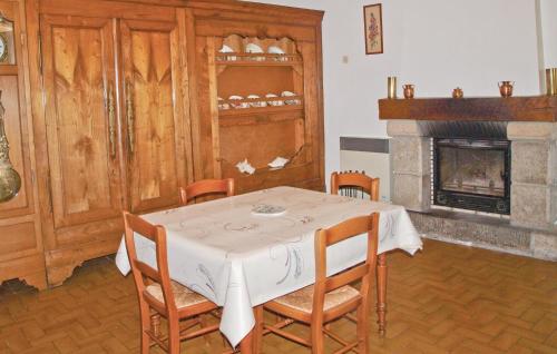 a dining room with a table and a fireplace at Holiday Home Kerbors Wx-1650 in Kerbors