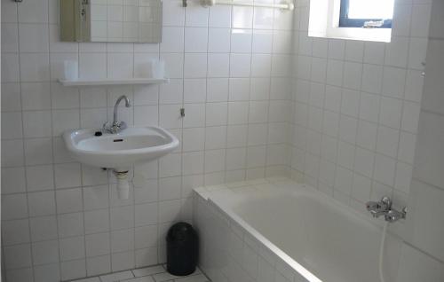 ユリアーナドルプにあるBeatrix 164の白いタイル張りのバスルーム(シンク、バスタブ付)