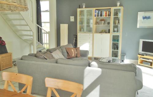 a living room with a gray couch and a staircase at Beatrix 164 in Julianadorp