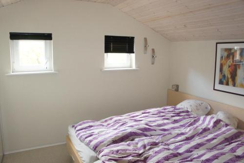 a bedroom with a bed and two windows at Ådalen (ID 093) in Esbjerg