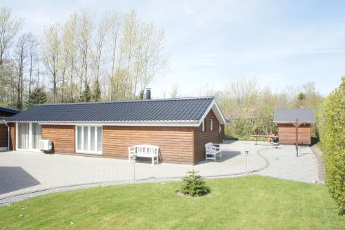 a small house with a patio and a picnic table at Ådalen (ID 093) in Esbjerg