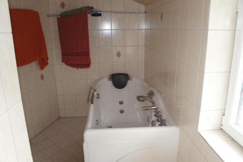 a bath tub in a bathroom with red towels at Ådalen (ID 093) in Esbjerg