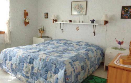 a bedroom with a bed with a blue quilt on it at Beautiful Home In Mattmar With 3 Bedrooms in Arvesund