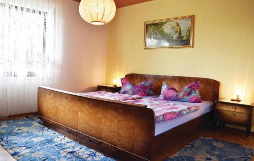a bedroom with a large wooden bed with purple pillows at Nice Apartment In Rickenbach With Wifi in Rickenbach