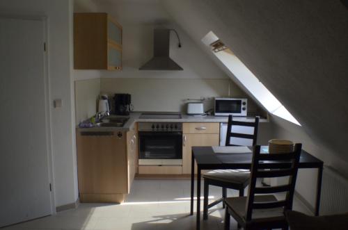 uma cozinha com um fogão e uma mesa com cadeiras em Ferienwohnung Tiberquelle em Dülmen