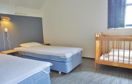 ユリアーナドルプにあるBeatrix 164のベッド2台とベビーベッド1台が備わる小さな客室です。
