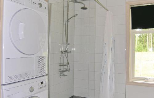 a shower with a washing machine in a bathroom at Cozy Home In Vittaryd With Sauna in Kvänarp