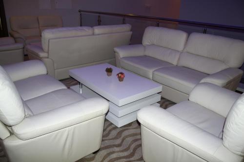 a living room with white couches and a table at Hotel Franca in Pljevlja
