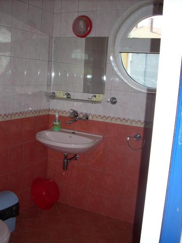 a bathroom with a sink and a mirror at The Colourful Mansion Hotel in Ahtopol