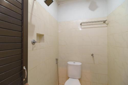 a bathroom with a white toilet and a shower at RedDoorz Syariah @ Panglima Nyak Makam Aceh in Banda Aceh