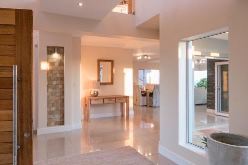 Sala de estar con puerta y mesa en Pezula Fairlead Luxury, en Knysna