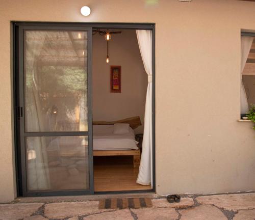 a sliding glass door leading to a bedroom at Gate Away B&B Units - המקום באל רום in El-Rom