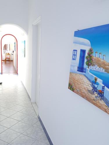 a picture of a hallway with a painting of a house at Pension Ptolemeos in Fira