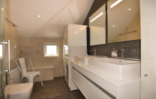 a white bathroom with a sink and a chair at Beautiful Home In Kyrkesund With Sauna in Kyrkesund