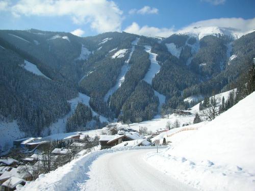 a snow covered mountain with a road in the foreground at Pension Margarete in Zell am See