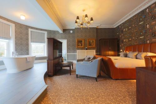 a large bedroom with a bed and a tub in it at Hotel du Vin Cannizaro House Wimbledon in London