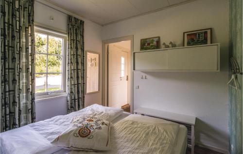 1 dormitorio con cama, ventana y estante en Amazing Home In Finsterwolde With 2 Bedrooms And Wifi, en Finsterwolde