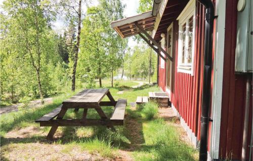 a picnic table sitting outside of a red building at Pet Friendly Home In Simlångsdalen in Älmhult