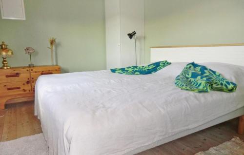 um quarto com uma cama branca com almofadas azuis em 2 Bedroom Stunning Home In Gunnebo em Skälö