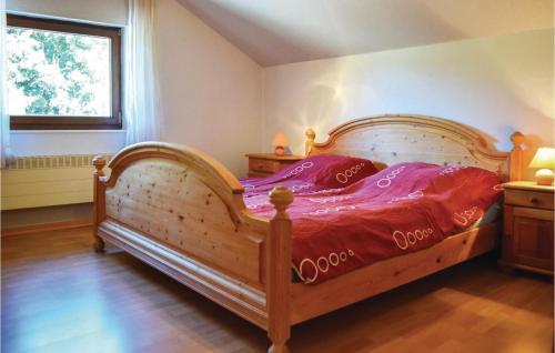 a bedroom with a wooden bed with purple sheets and a window at Cozy Home In Sellerich With Kitchen in Sellerich