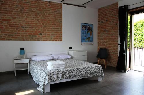 a bedroom with a bed and a brick wall at Casa Lidia locazione breve in Agliano Terme