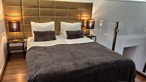 布達佩斯的住宿－行星假日公寓酒店，一间卧室配有一张大床和两盏灯