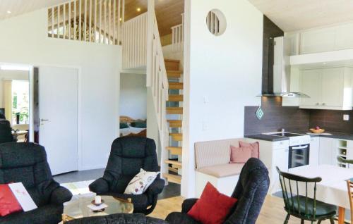 a living room with chairs a table and a kitchen at Holiday Home Sandåkra Vetlanda in Vetlanda