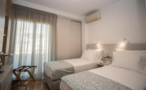 pokój hotelowy z 2 łóżkami i oknem w obiekcie Alex's place w mieście Vari
