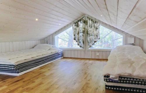 2 Bedroom Cozy Home In Vetlanda في فيتلاندا: سريرين في غرفة بها نافذتين