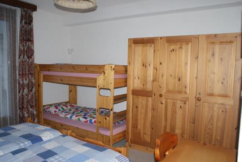 ein Schlafzimmer mit einem Etagenbett mit einer Leiter in der Unterkunft Des Alpes in Davos