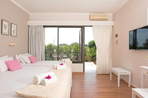 a bedroom with two beds and a large window at Ipsos Holidays in Ipsos