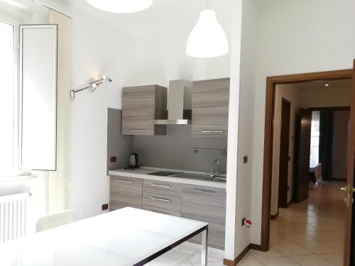 a kitchen with white cabinets and a white table at Villa Anita - appartamento green in Pescara