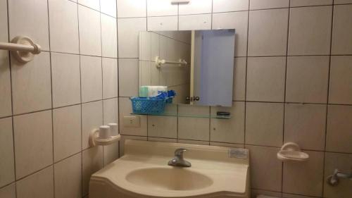 een badkamer met een wastafel en een spiegel bij Zhiben Hot Spring Hsiao Hotel in Wenquan