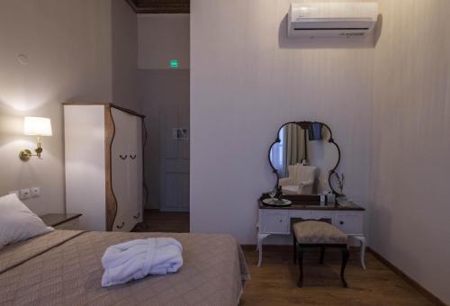 a bedroom with a bed and a desk with a mirror at Agora Residence in Chios