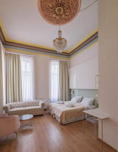 a bedroom with a bed and a couch and a chandelier at Agora Residence in Chios