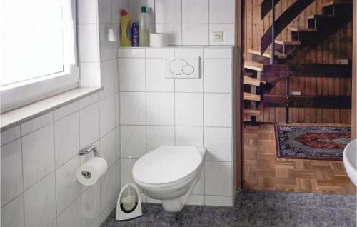 Baño blanco con aseo y lavamanos en Amazing Home In Alpirsbach-rmlinsdorf With 2 Bedrooms, en Marschalkenzimmern