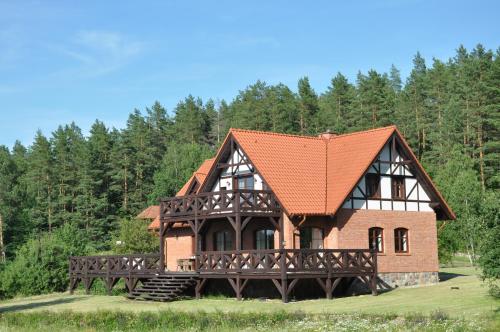 una casa con techo naranja y un puente en Zakątek Sary, en Jonkowo