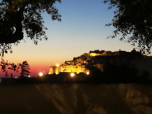 a view of a lit up city at sunset at Hotel Monte Sarago in Ostuni