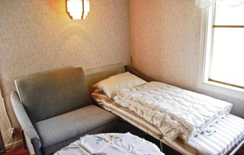 a bed and a chair in a room with a window at Kvighult in Forsvik