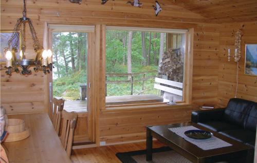 a living room with a large window in a log cabin at Roligheten in Vanvik