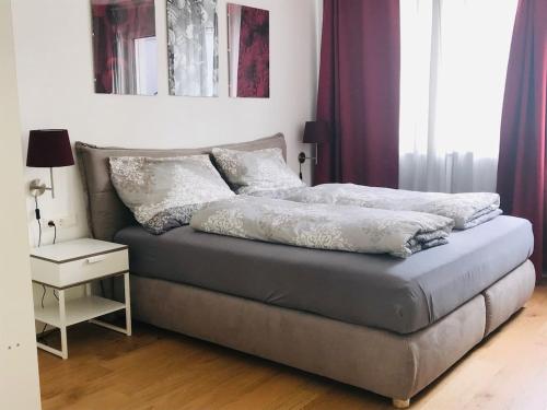 un letto con cuscini sopra in una camera da letto di Red Flower Apartment with Pool - 5 min to Lake a Vienna
