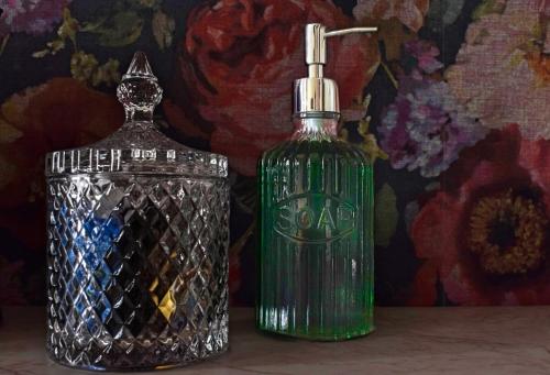 a green bottle of soap next to a glass container at Agora Residence in Chios