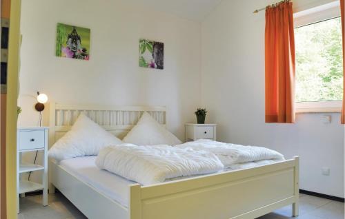 Schlafzimmer mit einem Bett mit weißer Bettwäsche und einem Fenster in der Unterkunft Awesome Home In Gerolstein-hinterhaus, With 3 Bedrooms And Wifi in Hinterhausen