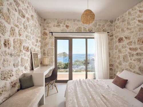 een slaapkamer met een bed, een bureau en een raam bij Apaggio Villa in Agios Nikolaos